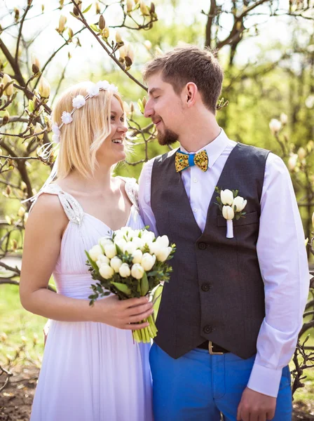 Щаслива наречена і наречена позує в парку біля весняних квітів на день весілля — стокове фото