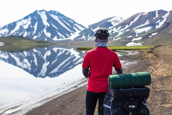 Biker on backdrop of lake and mountains — Stok fotoğraf