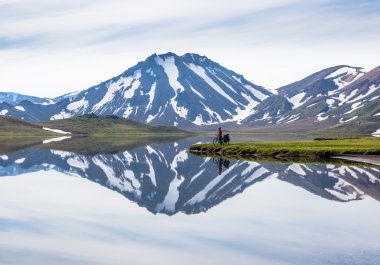 biker on backdrop of lake and mountains