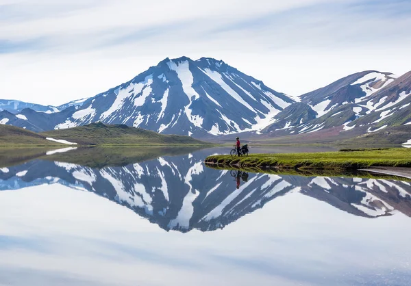 biker on backdrop of lake and mountains