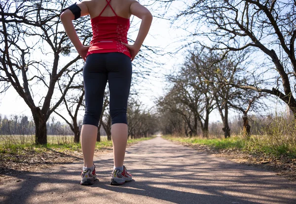 Sport kvinna jogging utanför i våren parken tidigt på morgonen — Stockfoto