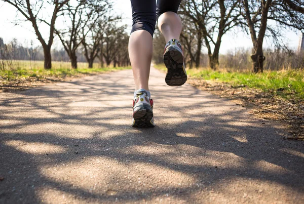 Sportlerin joggt frühmorgens im Frühlingspark — Stockfoto