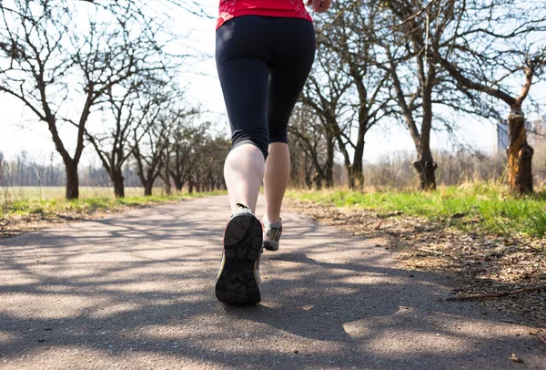 Deporte mujer corriendo fuera en primavera parque temprano por la mañana — Foto de Stock