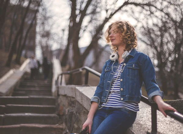 Young Hipster curly woman listening to music in the city — Stock Photo, Image