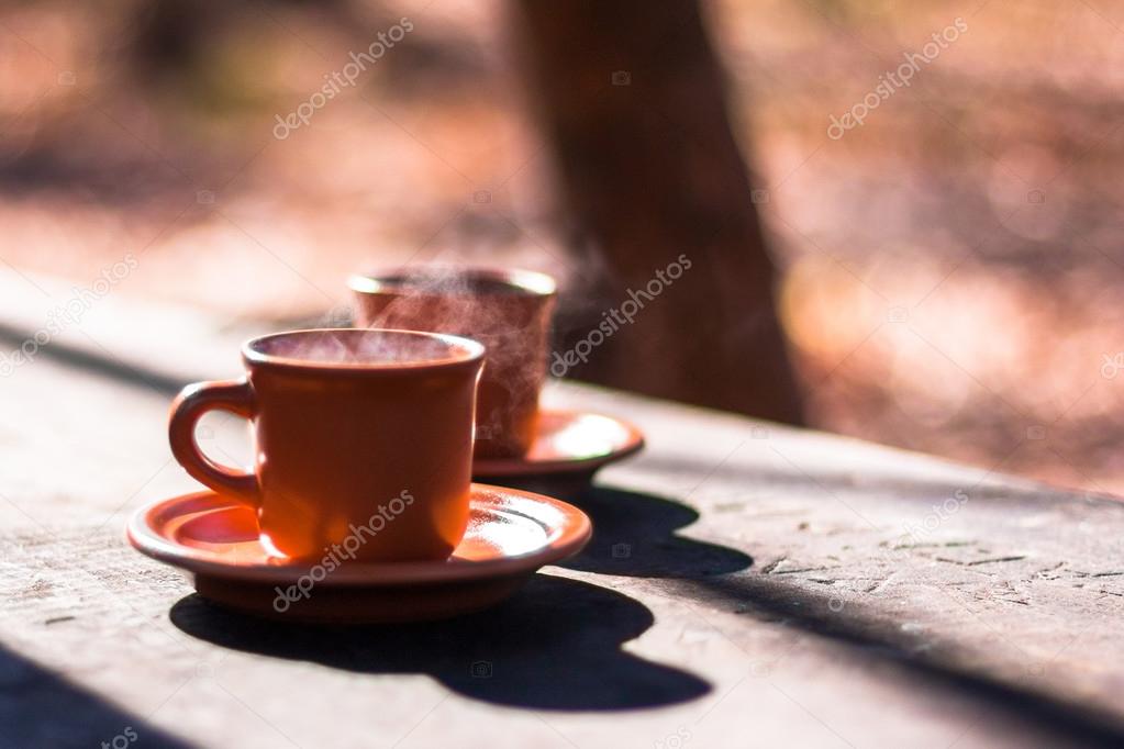 two cups of hot tea on wood background in autumn