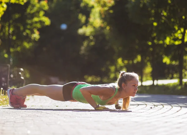 Mujer joven entrenando en el parque de la ciudad en el día de verano —  Fotos de Stock