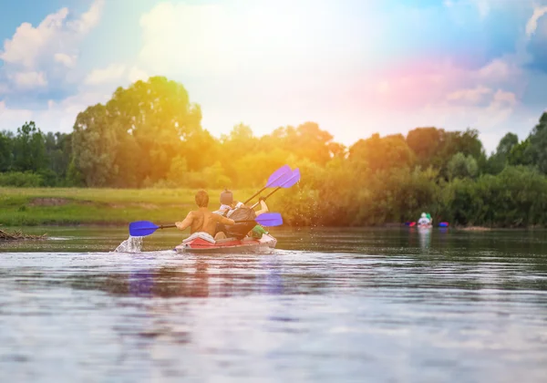 Los jóvenes están navegando en kayak por un río en una hermosa naturaleza de verano —  Fotos de Stock