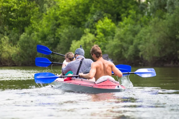 Junge Leute paddeln auf einem Fluss in herrlicher Sommernatur — Stockfoto