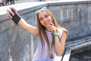 Genç öğrenci kız selfie yapım ve Şehir Parkı içinde dinlenmek