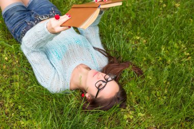 Şık öğrenci kız güneşli gün güzel yaz park kitap ile rahatlayın. Açık hava yaşam tarzı resim