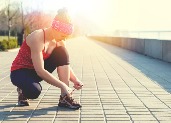 Sportlerin bindet beim morgendlichen Training Laufschuhe — Stockfoto