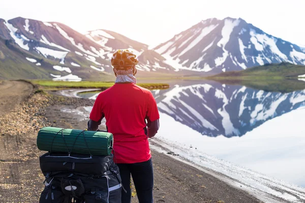 Motociclista feliz no pano de fundo do lago e nevando montanhas na Islândia — Fotografia de Stock