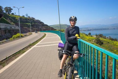 Geri kalan yolda güneşli bir günde sahip bisikletçi