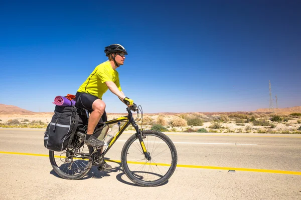 幸せなバイクに乗る人は、イスラエルの砂漠で美しい道路でリラックスします。晴れた暑い日 — ストック写真