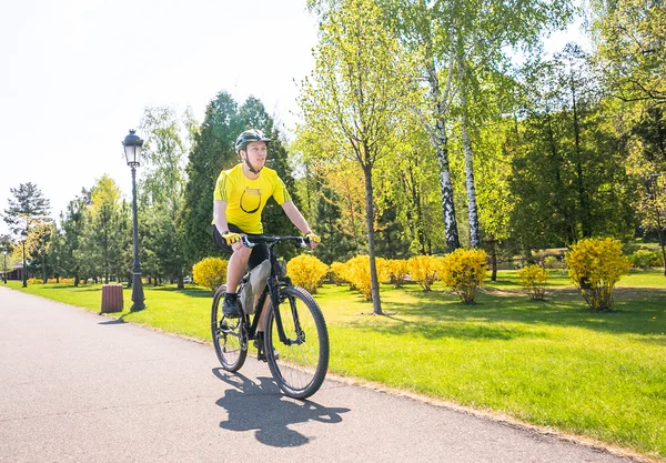 Szczęśliwy biker jeździć na drodze, w parku miejskim latem. Relaks sport concept — Zdjęcie stockowe