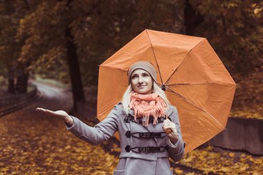 Sonbahar zaman dışında şemsiye poz ile genç güzel kadın