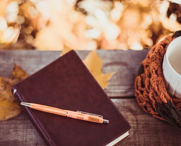 Горячий кофе и красная книга с осенними листьями на древесном фоне - концепция релакса — стоковое фото