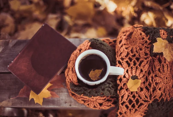 Hete koffie en rode boek met najaar bladeren op hout achtergrond - seizoensgebonden ontspannen concept — Stockfoto