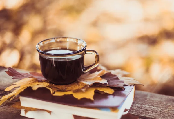 Hete koffie en rode boek met najaar bladeren op hout achtergrond - seizoensgebonden ontspannen concept — Stockfoto