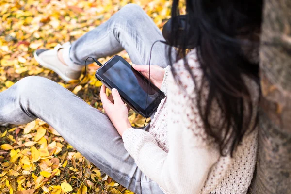 젊은 행복 한 십 대 소녀 그녀의 태블릿을 사용 하 고가 공원에 음악을 듣고. 가 생활양식 그림 — 스톡 사진