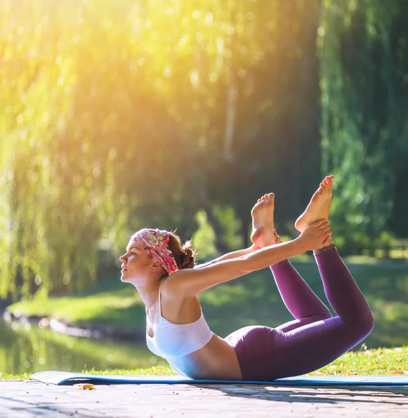 Mujer joven haciendo yoga en el parque matutino — Foto de Stock