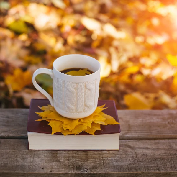 Café caliente y libro rojo con hojas de otoño sobre fondo de madera — Foto de Stock