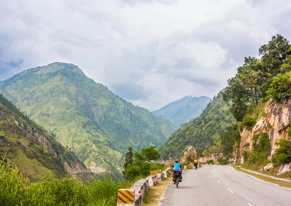Jóvenes ciclistas pasean en un roud de montaña en Himalaya, India — Foto de Stock