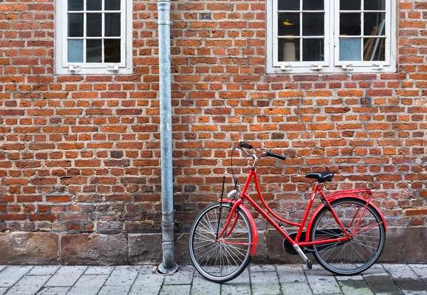 Bicicleta vermelha perto de parede vermelha em Copenhague, Dinamarca — Fotografia de Stock