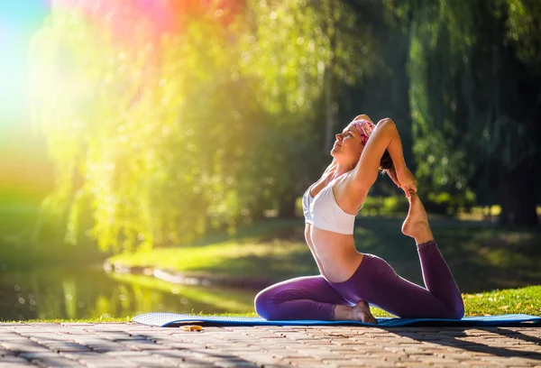 Mujer joven haciendo yoga en el parque matutino —  Fotos de Stock