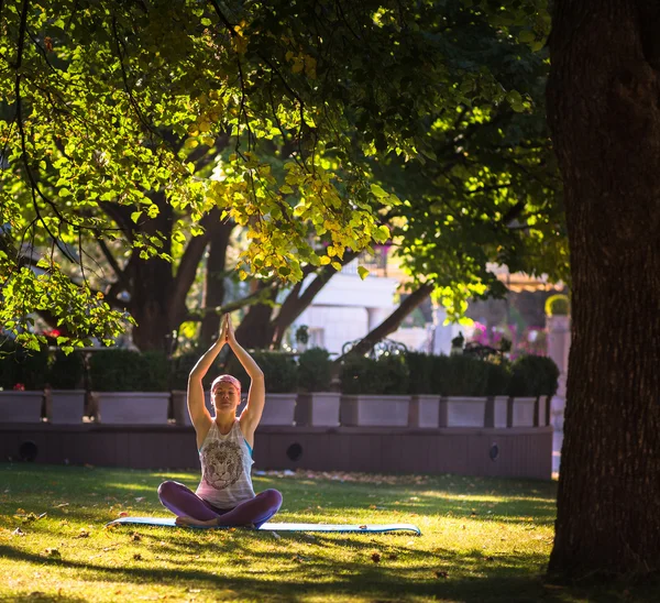 Jovem fazendo ioga no parque da manhã — Fotografia de Stock