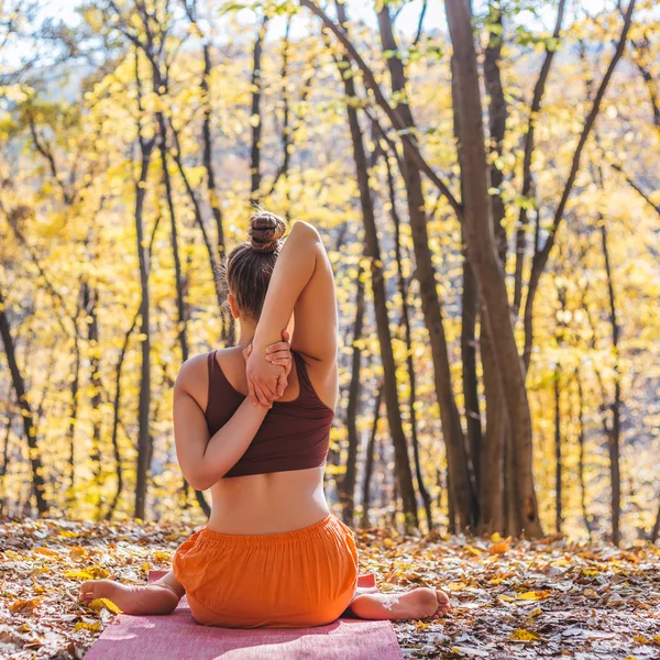 Giovane donna che fa yoga nel parco di autunno del mattino — Foto Stock