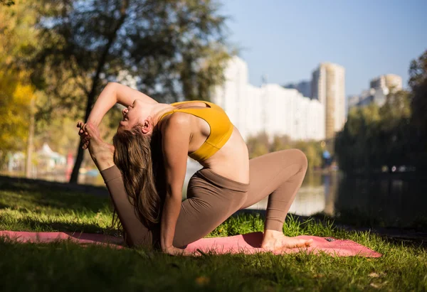 Wanita muda melakukan yoga di pagi hari di taman musim gugur — Stok Foto