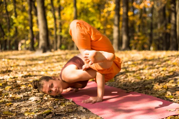 Young woman doing yoga in morning autumn park — Stock Photo, Image