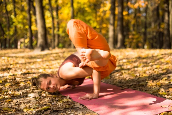 Mujer joven haciendo yoga en el parque de otoño de la mañana —  Fotos de Stock