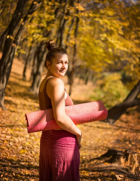 朝秋の公園でヨガを行う若い女性 — ストック写真