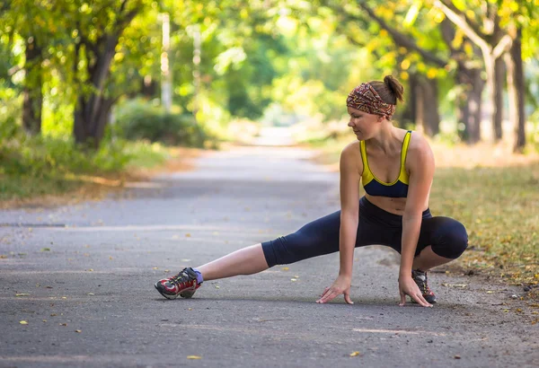 Spor kadının açık çapraz eğitim egzersiz sırasında germe yapması — Stok fotoğraf