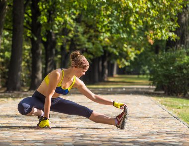 Spor kadının açık çapraz eğitim egzersiz sırasında germe yapması