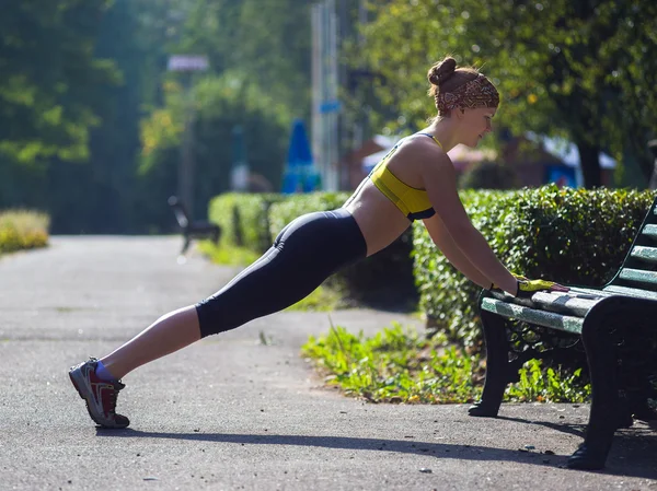 Sport kvinna gör armhävningar under utomhus crosstraining verk — Stockfoto