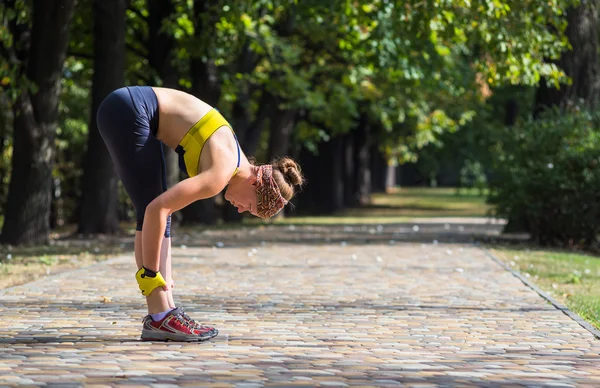 Mujer del deporte haciendo estiramiento durante el entrenamiento de entrenamiento cruzado al aire libre —  Fotos de Stock