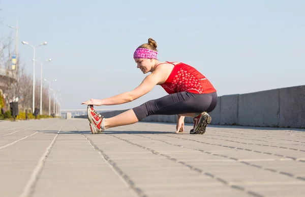 Mujer deportiva entrenando fuera en muelle de la ciudad por la mañana — Foto de Stock