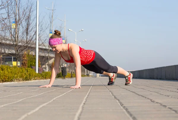 Sport wanita melakukan push-up di luar di pagi hari — Stok Foto