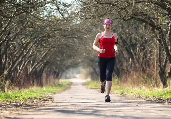 Спортивная женщина бегает во время тренировки на улице утром — стоковое фото