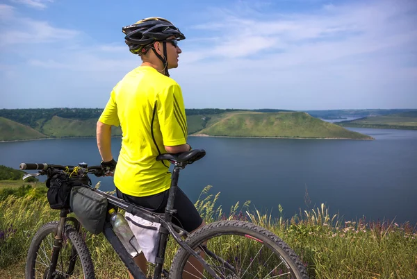 Genç bisikletçi rahatla Nehri yakınında güzel doğada — Stok fotoğraf