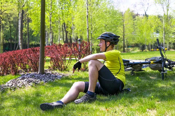 Biciclista tendo descanso no parque da cidade — Fotografia de Stock