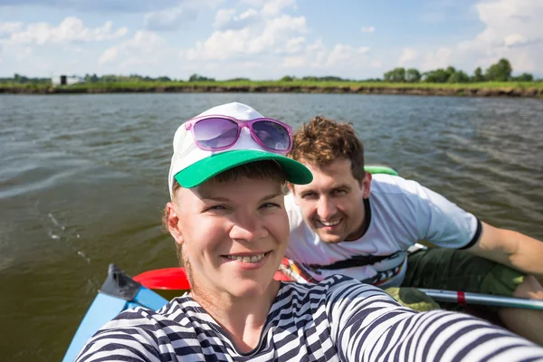 Unga människor får selfie under kajakpaddling på en flod i vacker natur — Stockfoto