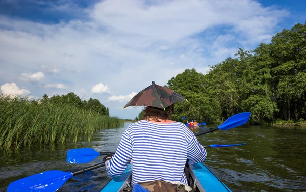 Junge Leute paddeln auf einem Fluss in schöner Natur — Stockfoto