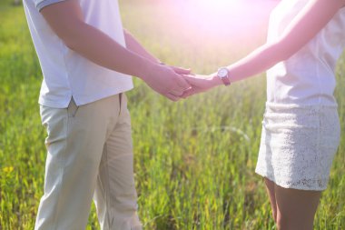 Elele yaz akşam günbatımında aşık genç Çift