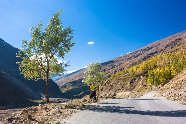 Joven ciclista de pie en la carretera de las montañas. Himalaya, Jammu y el estado de Cachemira, norte de la India —  Fotos de Stock