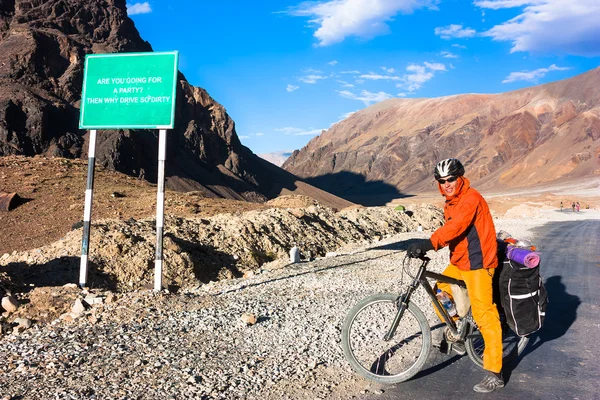 Jovem ciclista de pé na estrada das montanhas. Himalaias, Jammu e Caxemira, Norte da Índia — Fotografia de Stock