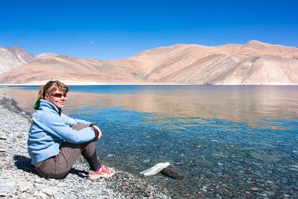 Jovem mulher está em Pangong Tso Lake em Ladakh, Jammu e Caxemira State, Índia . — Fotografia de Stock